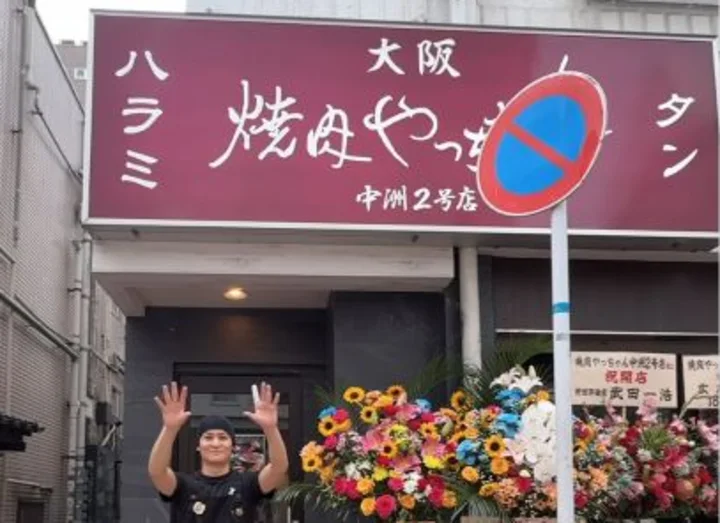 焼肉やっちゃん 中洲2号店 店頭の人物と看板、オープン祝花